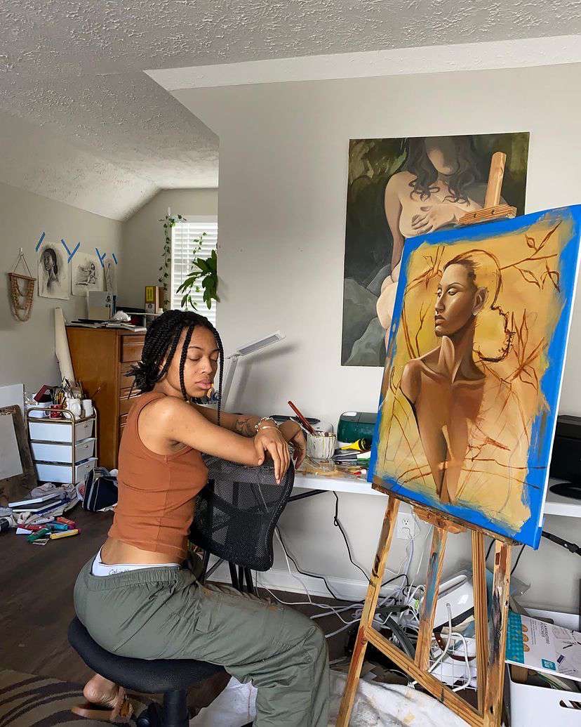 Jaylaart working beside the painting
