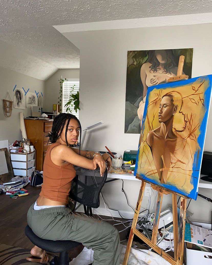 Jaylaart seated beside the artwork